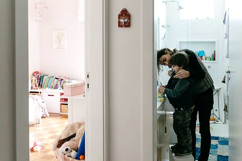 Mãe ajudando seu filho a escovar os dentes - Imagem de Mika Amanto, do projeto "A day in the life of...", que mostra cotidianos de famílias pelo mundo.
