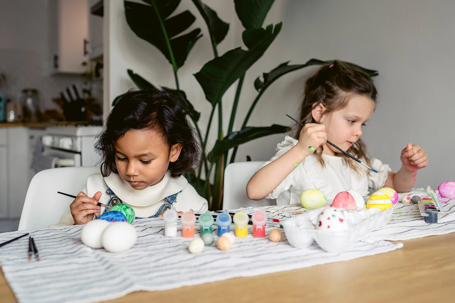 Duas meninas pintando ovos de Páscoa 2023 - Just Real Moms