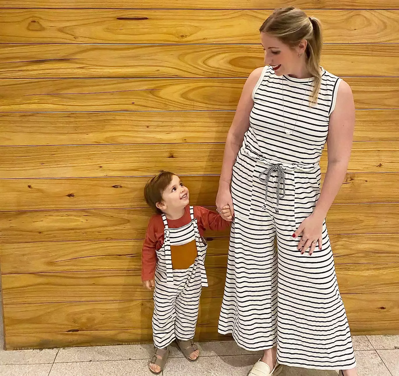 Bianca Zanini com seu filho Francisco em frente de parede de madeira - Just Real Moms