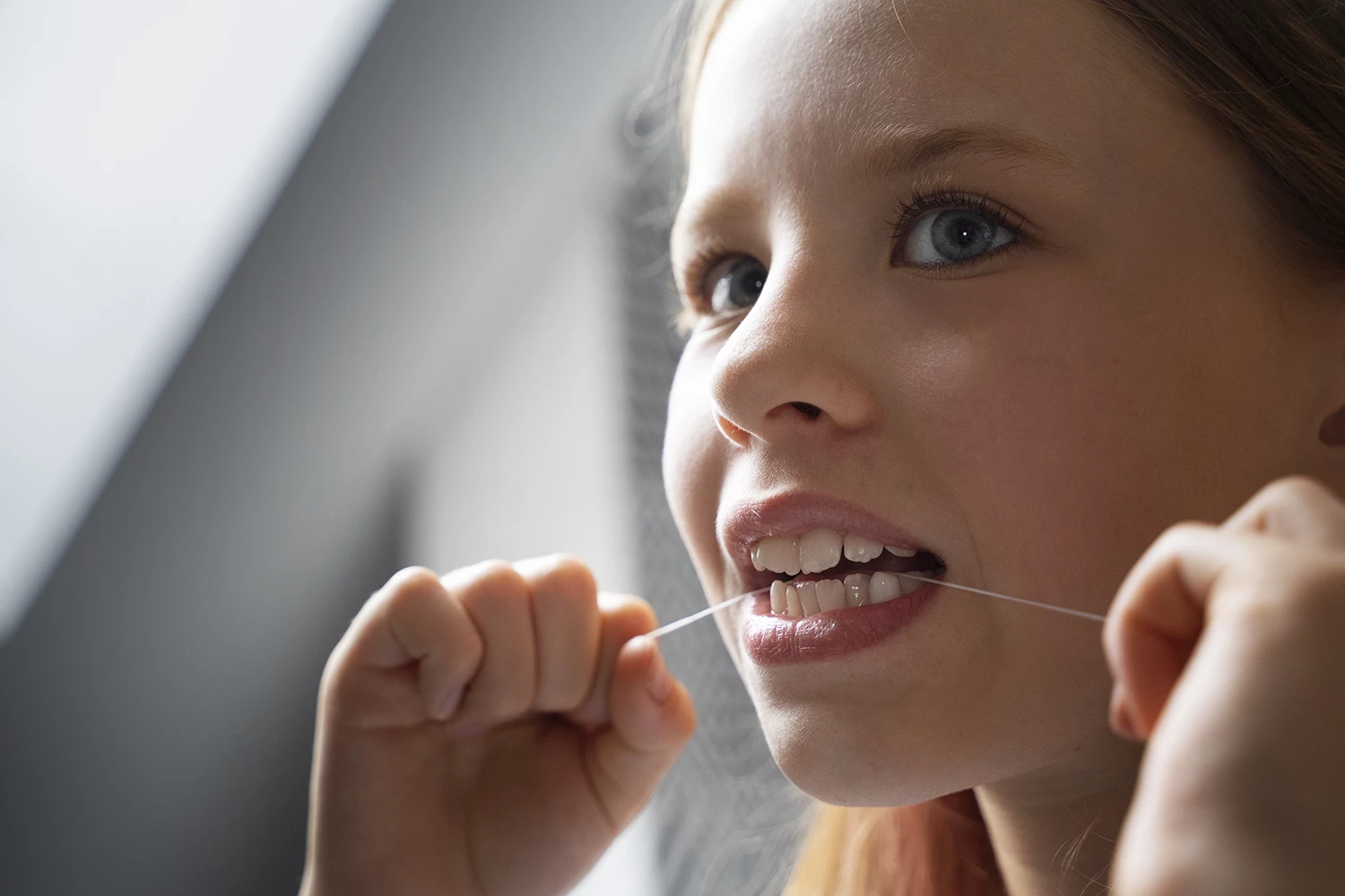 Menina passando fio dental - Just Real Moms