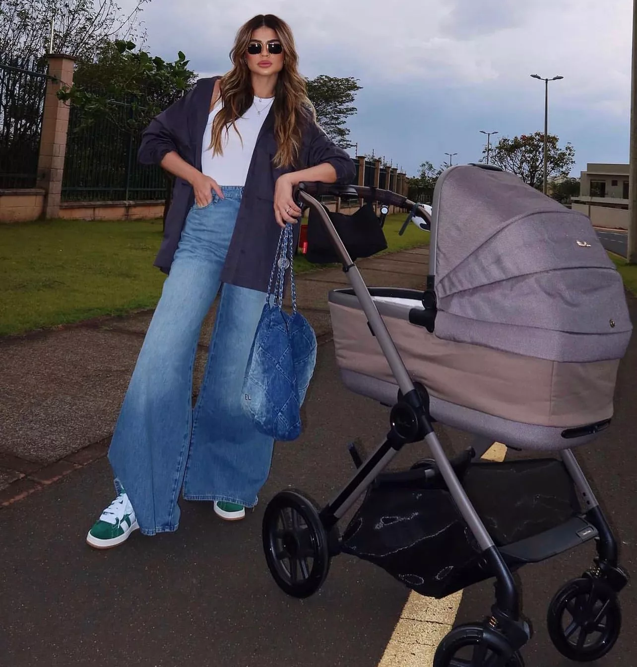 Thassia Naves ao lado do carrinho de seu bebê