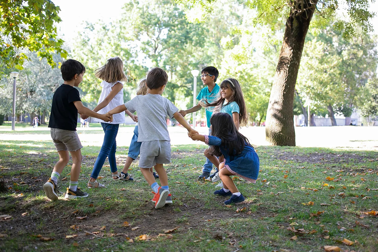 Crianças brincando em circulo de mãos dadas no parque