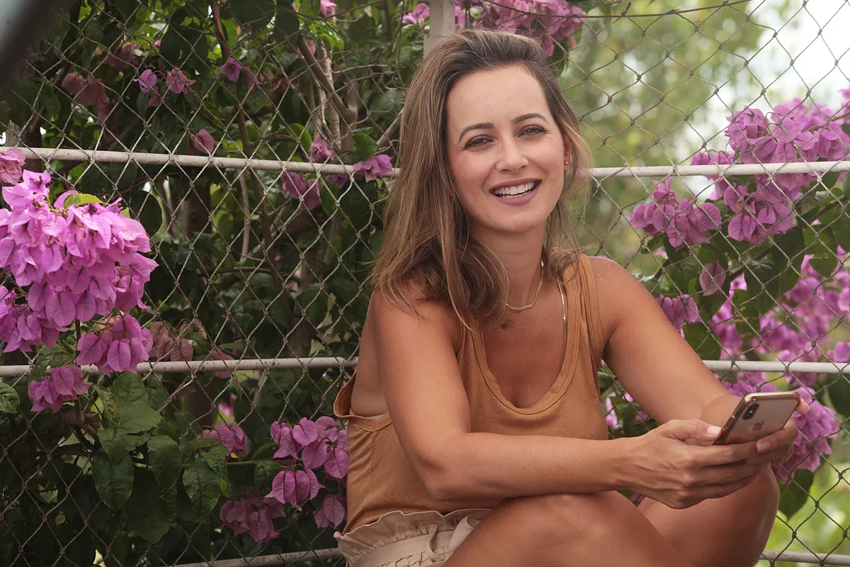 Larissa Cesco, Astróloga sentada em área externa com flores