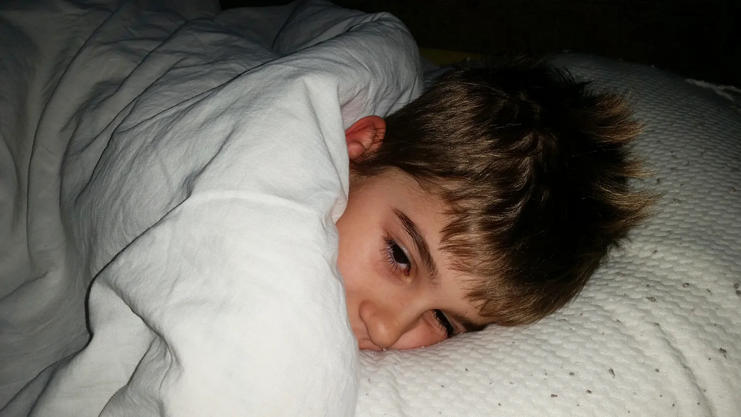 Menino - Higiene do sono na infância e adolescência - Just Real Moms Menino pequeno deitado na cama acordado de madrugada