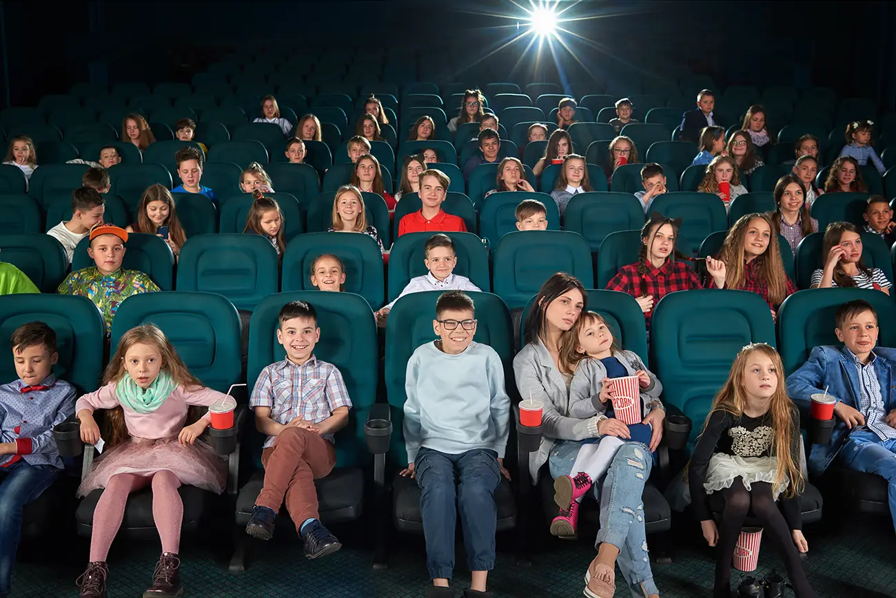 Cinema cheio de crianças com alguns pais