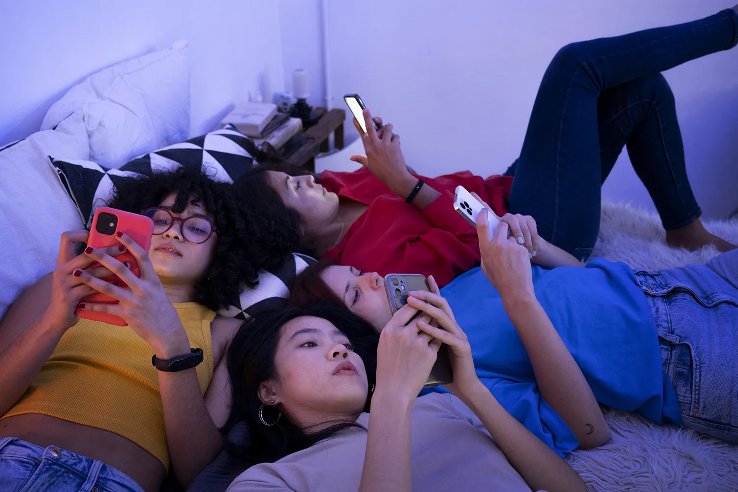 meninas adolescentes deitadas na cama todas vendo celulares