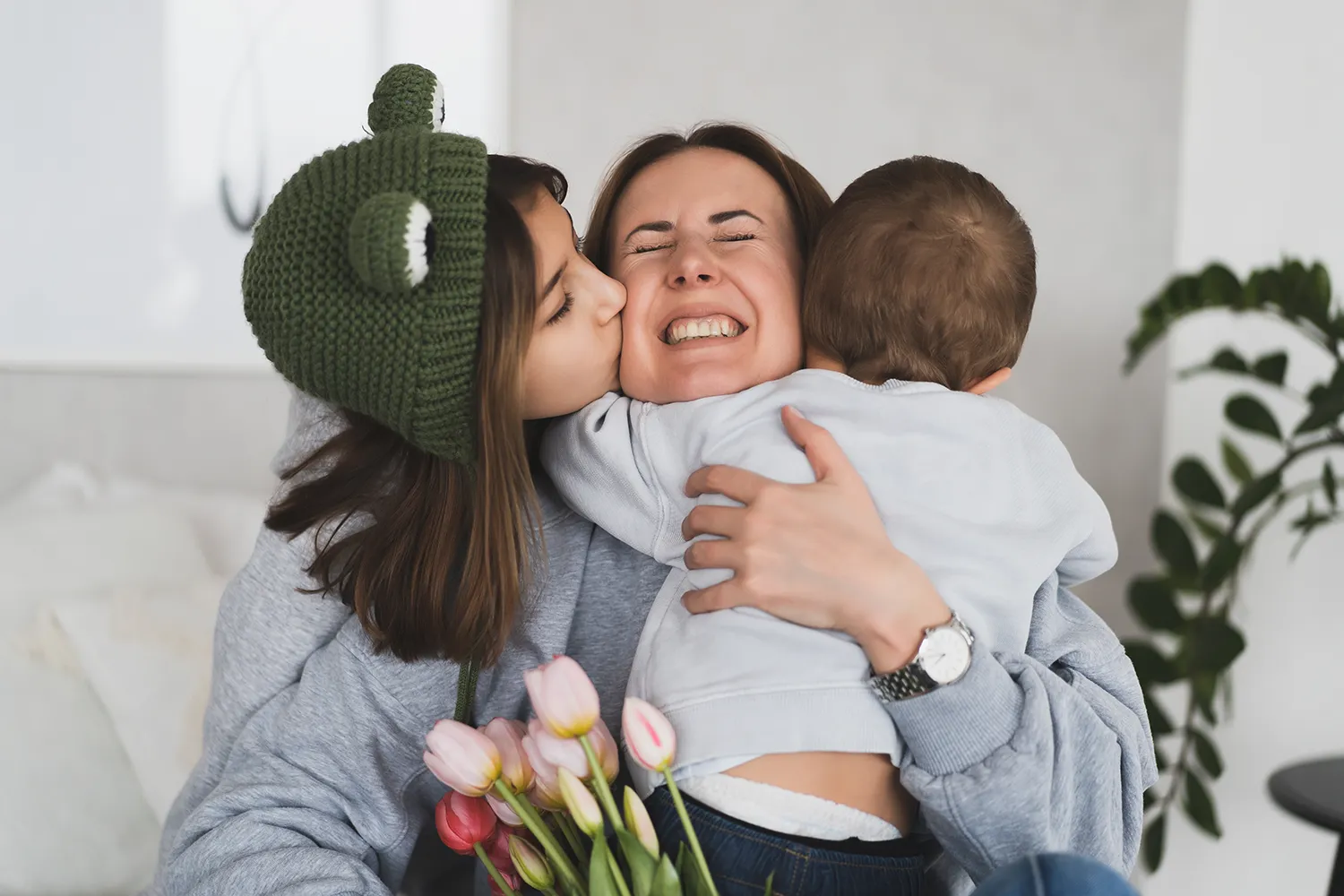 Mãe abraçando os filhos no Dia das Mães 2025