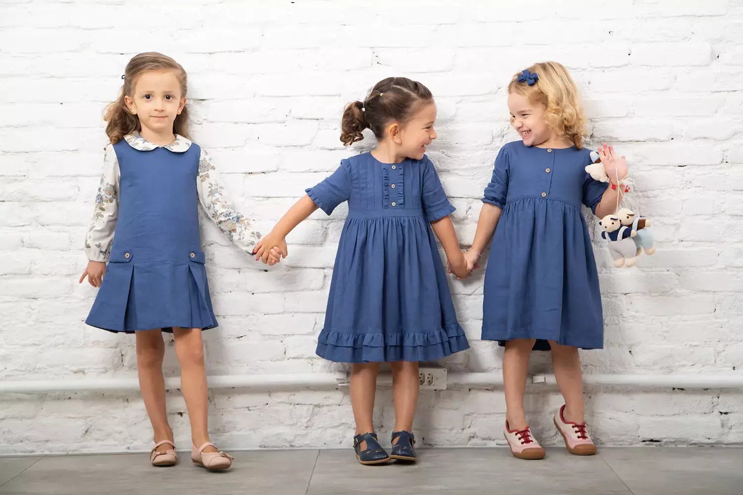 3 meninas dando risada vestindo roupas da Cris Moretti Moda Infantil - Just Real Moms