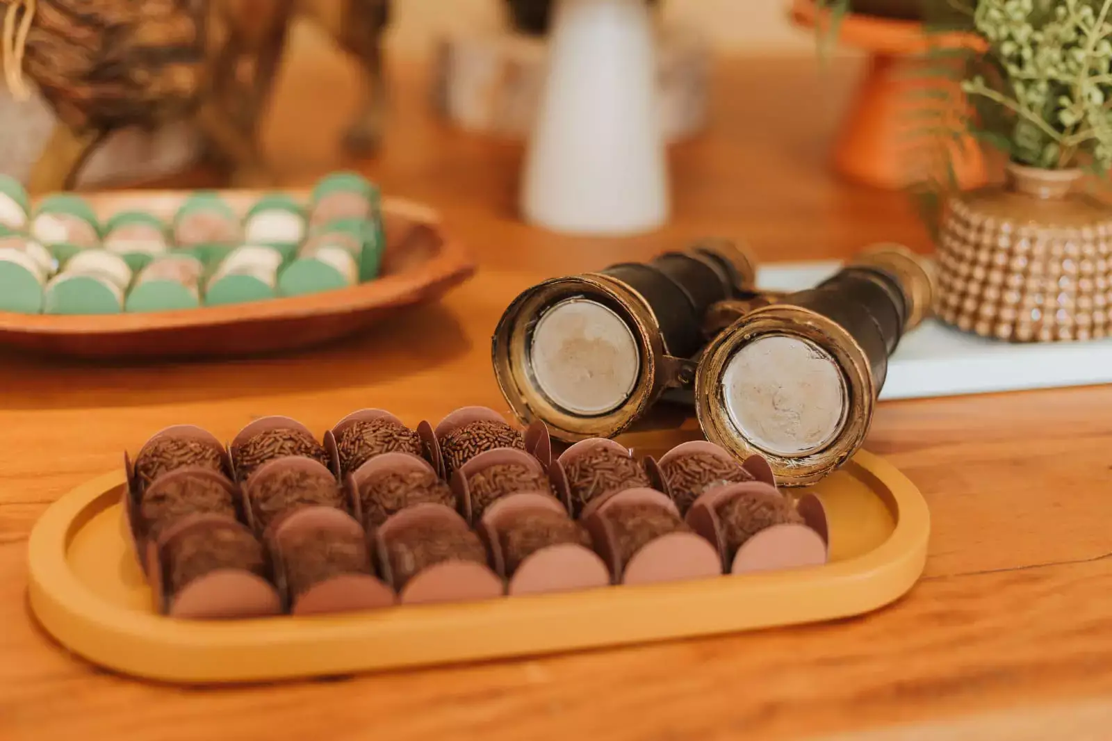 Brigadeiro em mesa de festa infantil com binóculo ao lado de decoração - Just Real Moms