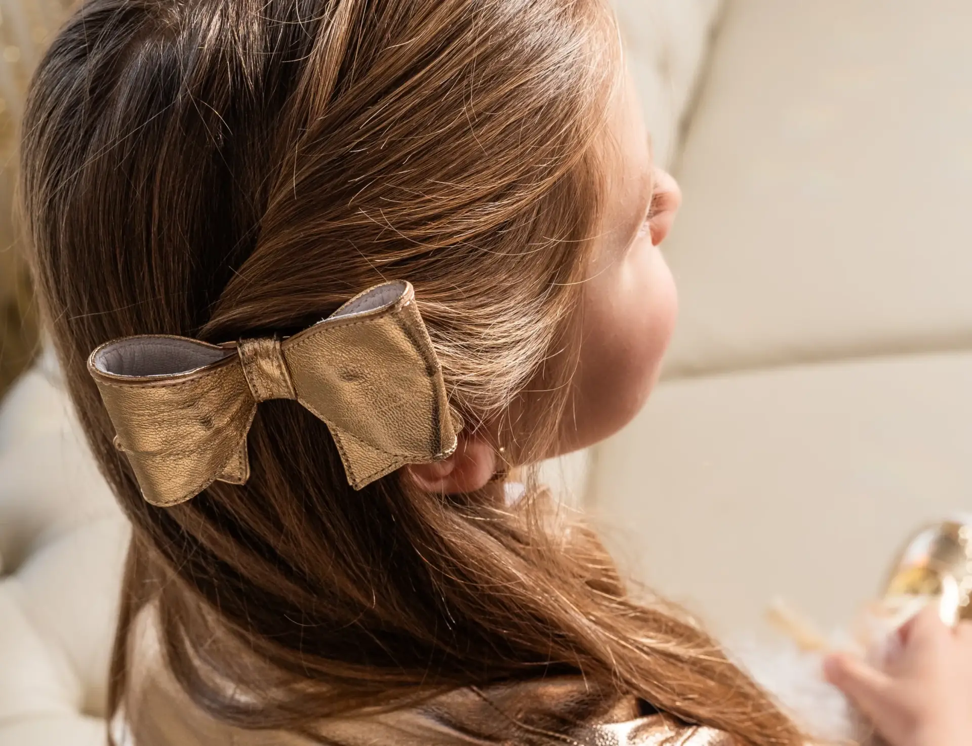Laço dourado de festa infantil da Amoreco Calçados