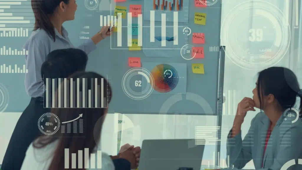 Equipe em reunião analisando indicadores e dados estratégicos em uma matriz de riscos aplicada à tomada de decisão em projetos de consultoria.